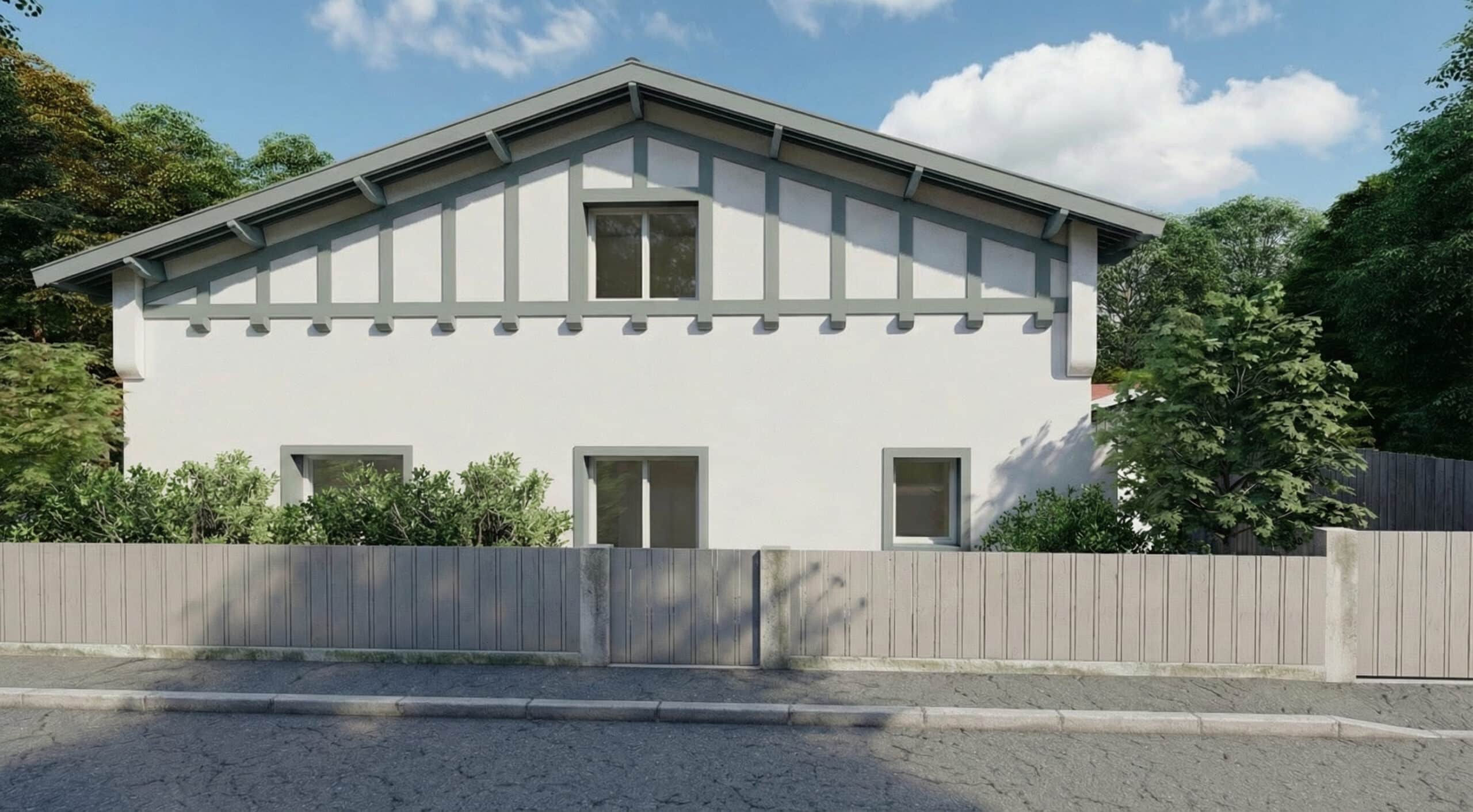 Maison de style basque à façade blanche, colombages gris et clôture en bois sous un ciel azur.